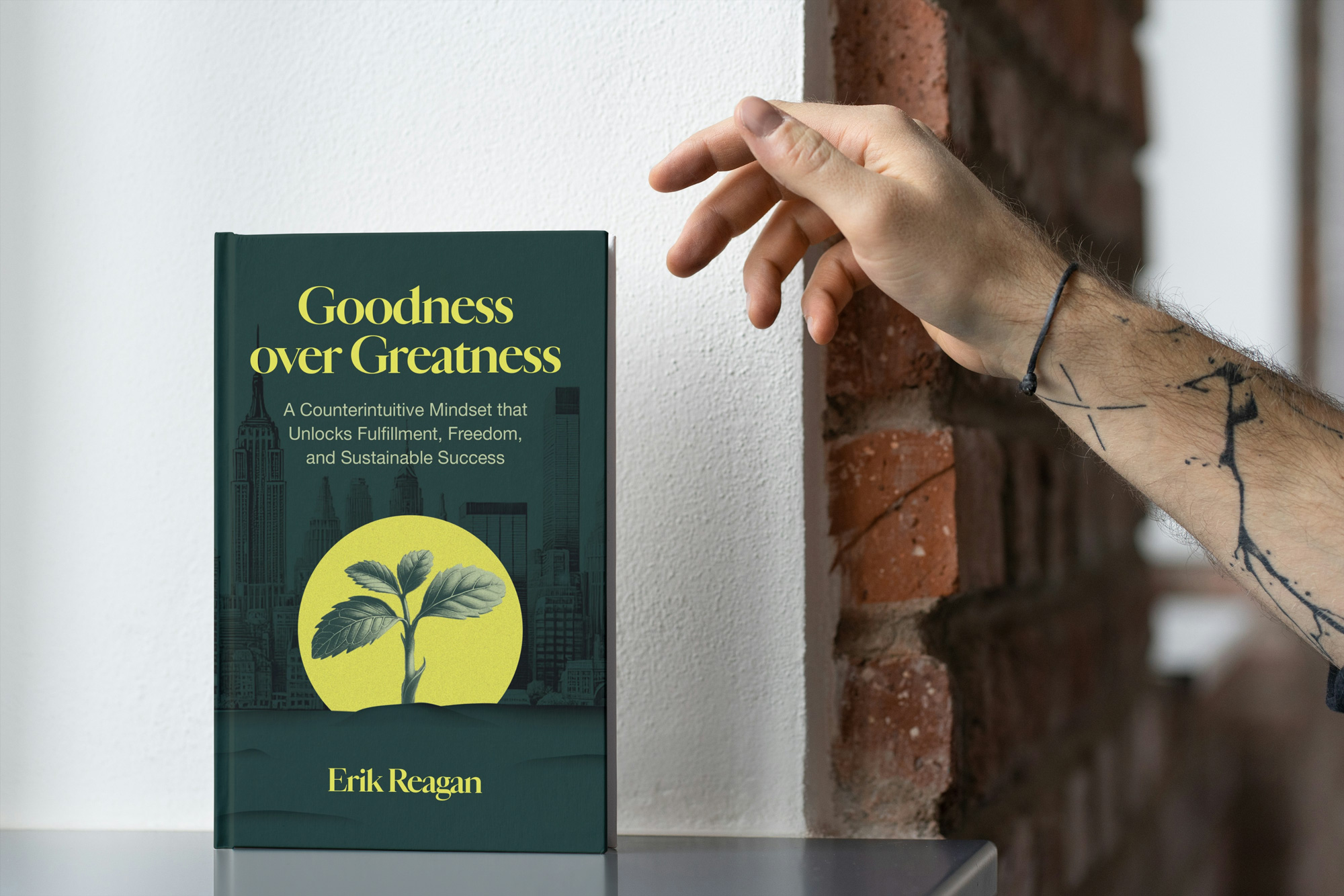 A hand reaching for the Goodness over Greatness book